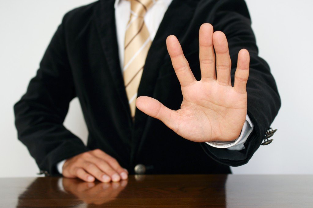 Man wearing a suit with hand outsretched in front of him