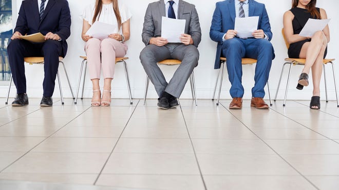 Five people sitting with resumes on hand