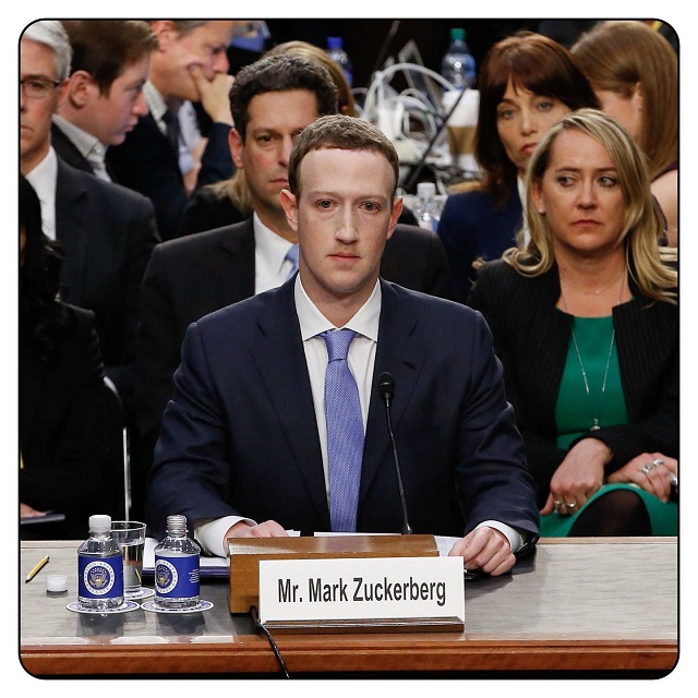 A grim-looking Mark Zuckerberg in navy-blue suit and light blue tie at the U.S. Congress in Washington