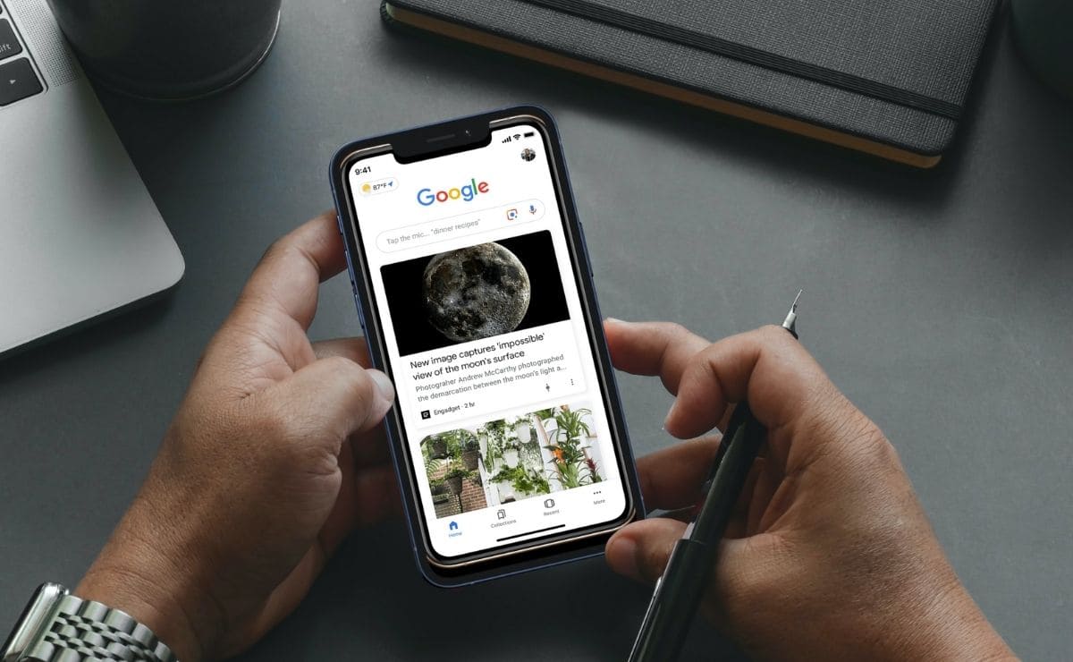 A hand holding a phone and pen in a google discover