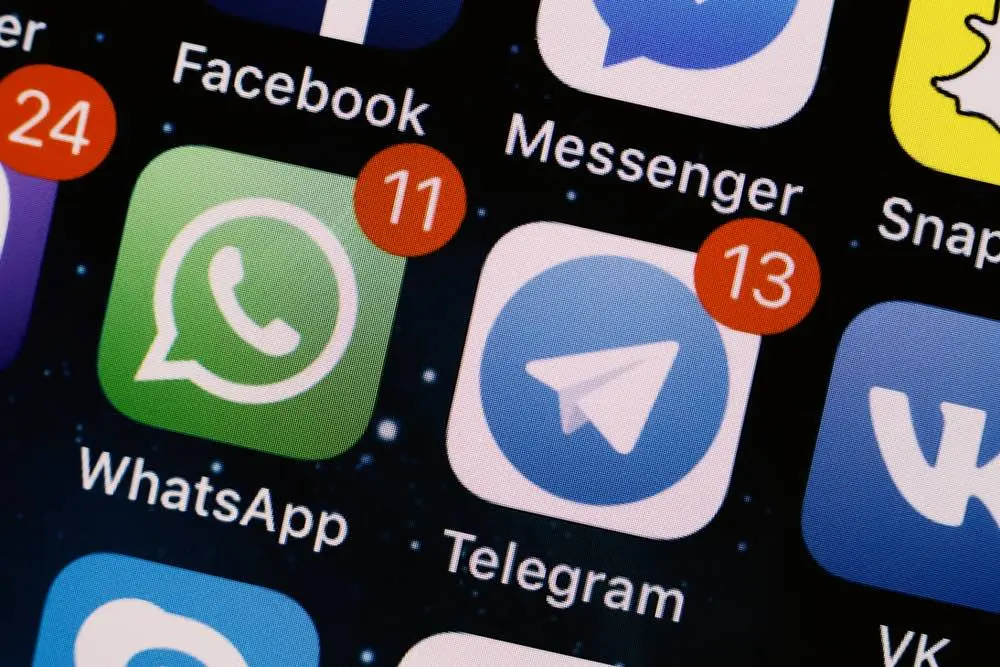 Telegram and WhatsApp icons on phone screen