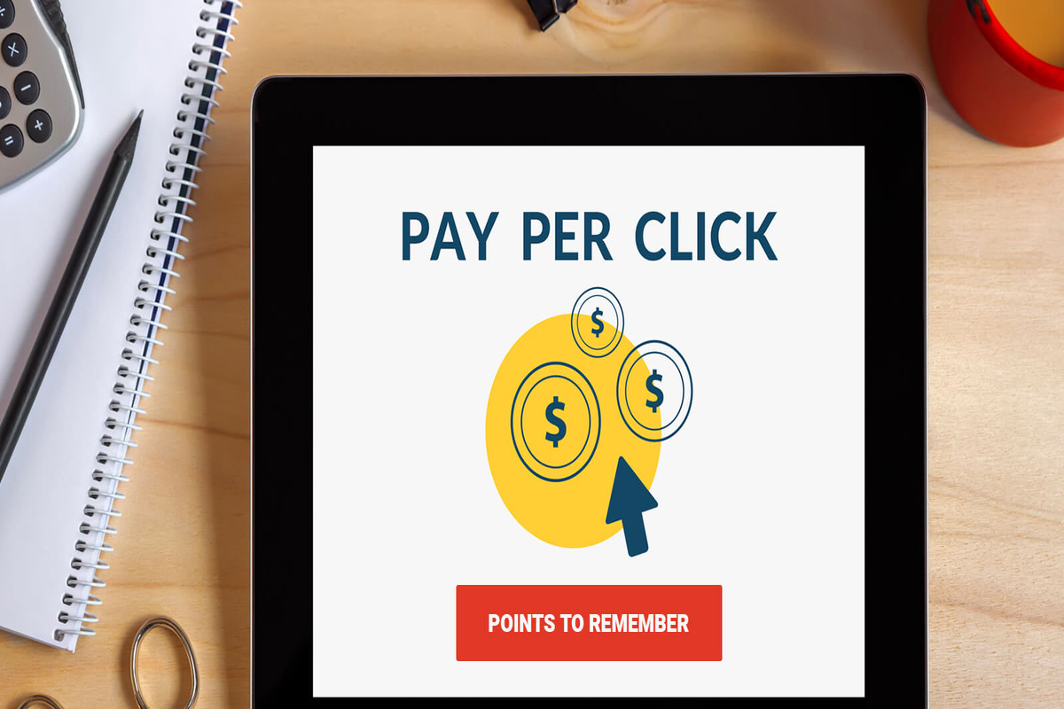 Pay per click, coins, and mouse cursor in a tablet