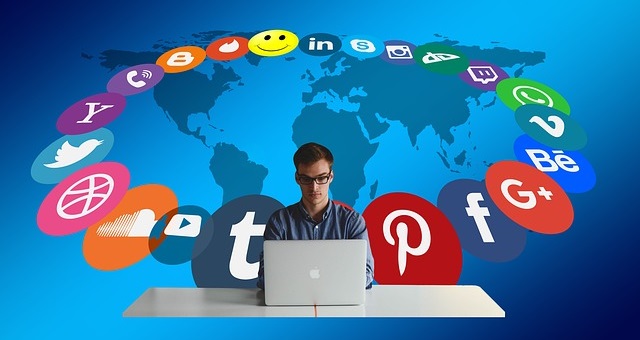 A man using laptop and social media logos at his back