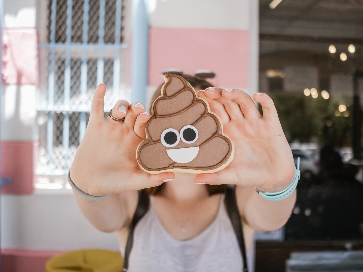 A girl holding a poop emoji chocolate bread