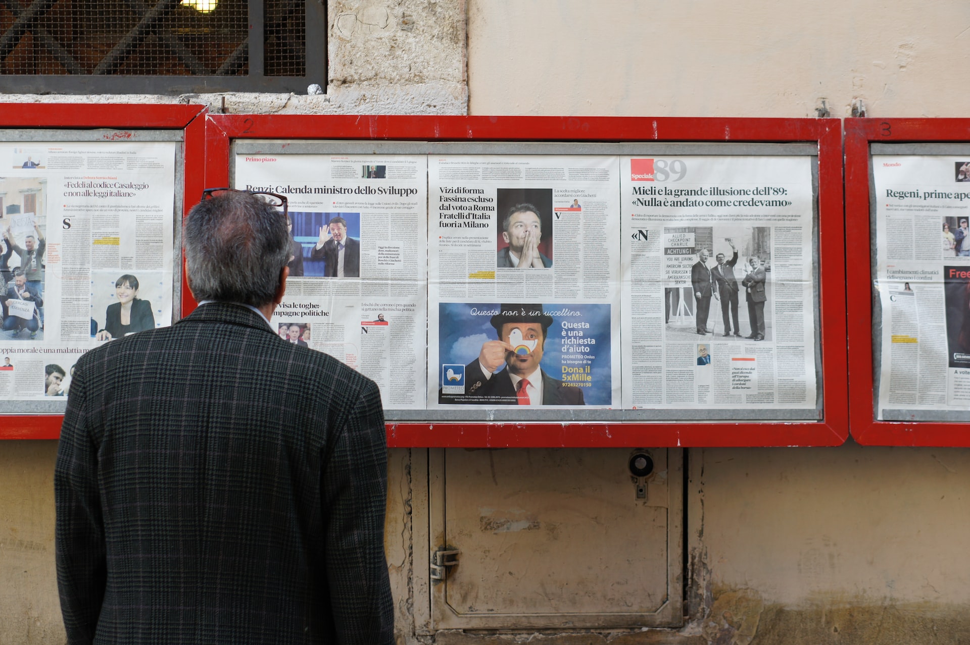 Man standing in front of newspapers
