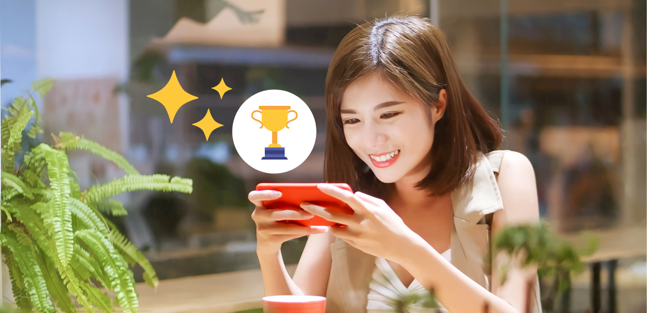 A woman smiling while playing games on the phone