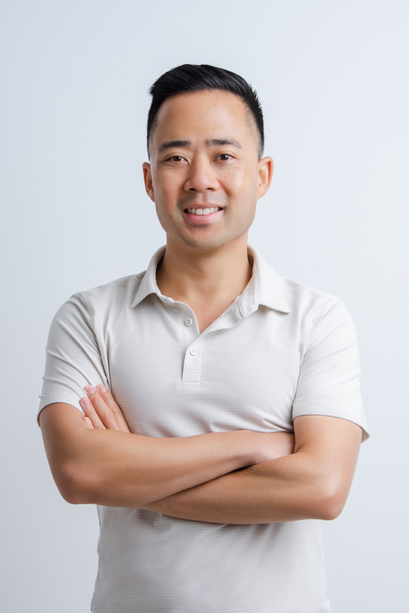 Smiling Eric Siu wearing a white polo shirt