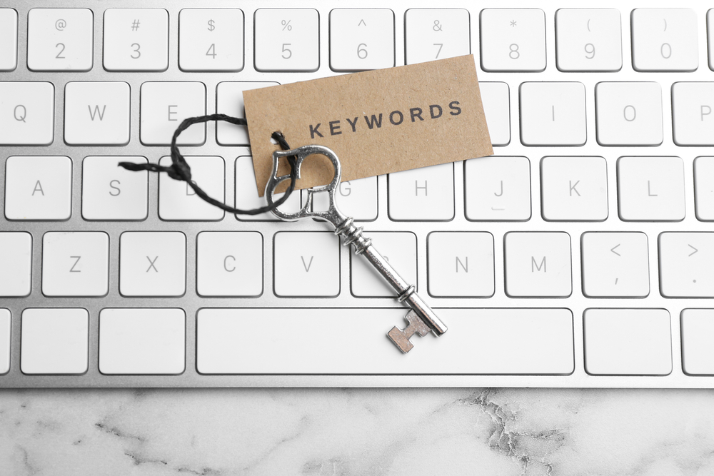 On top of a keyboard, a key with the word "KEYWORDS" written on it