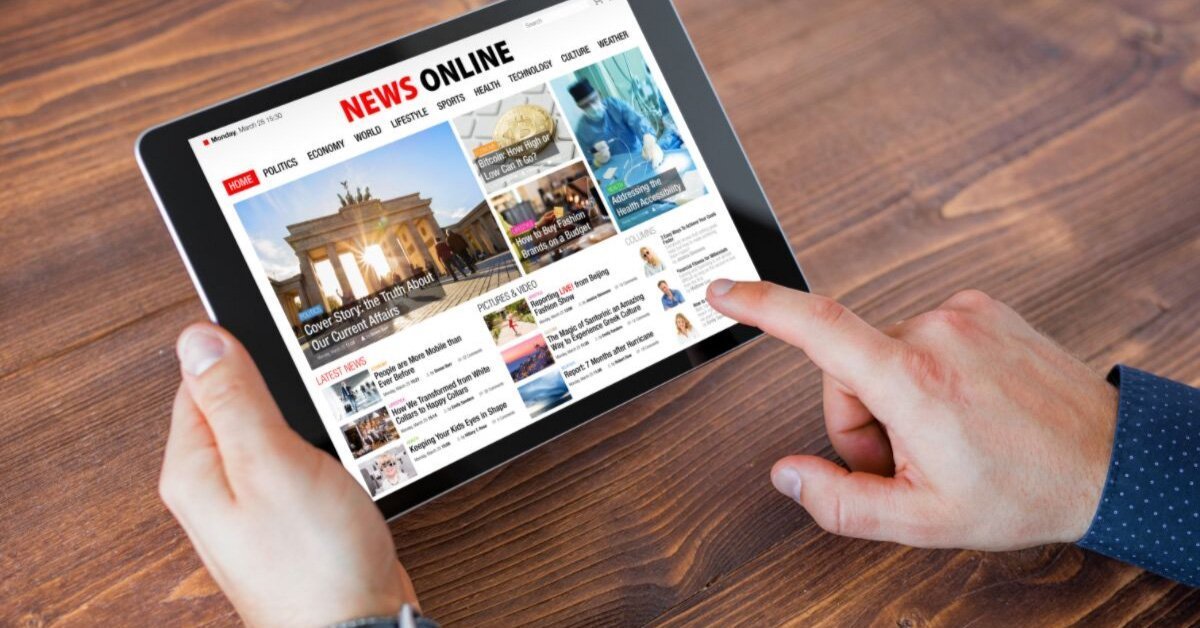 Hand scrolling on news website on a black tablet