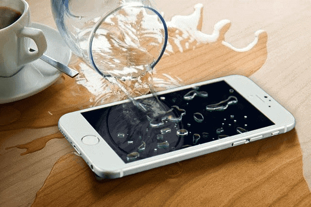 Water spilled to a white iphone because of spilled water from glass