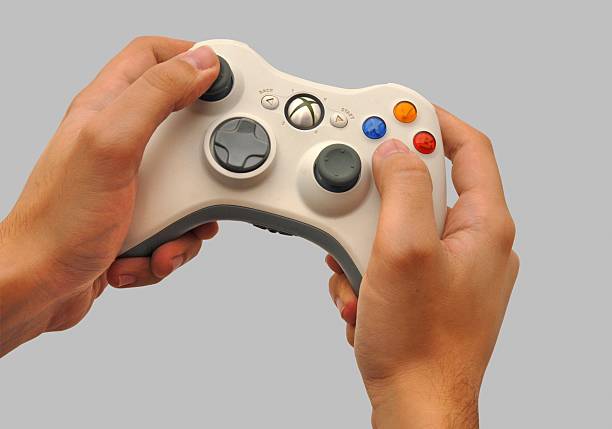 A pair of hands holding a white XBox controller.