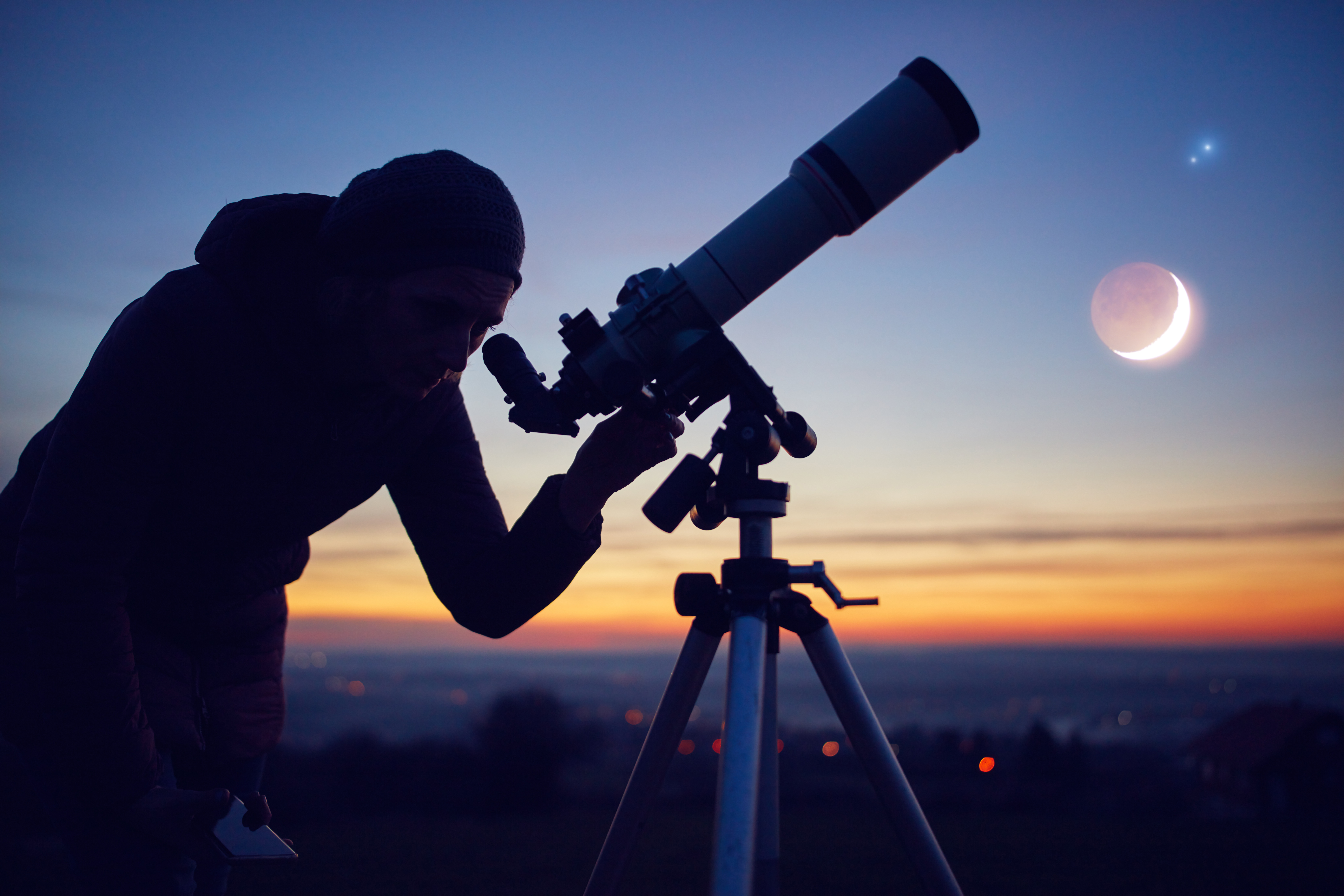 A person with a telescope stargazing