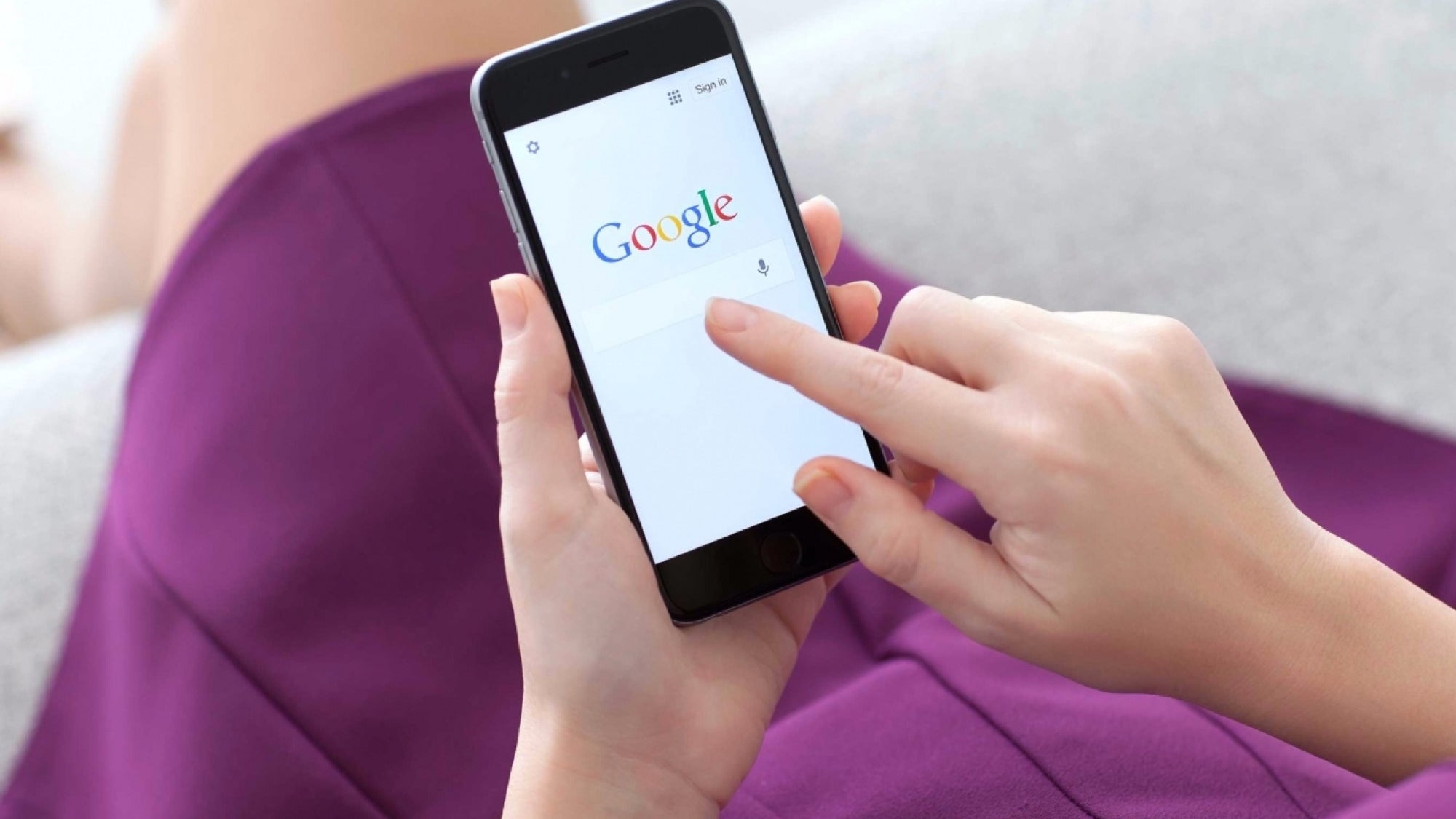 A woman in purple dress holding a phone on Google search engine