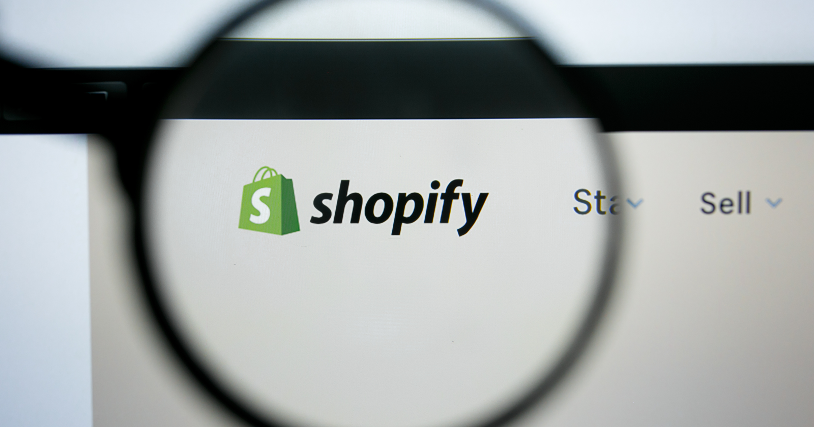 Shopify logo and website on a magnifying glass
