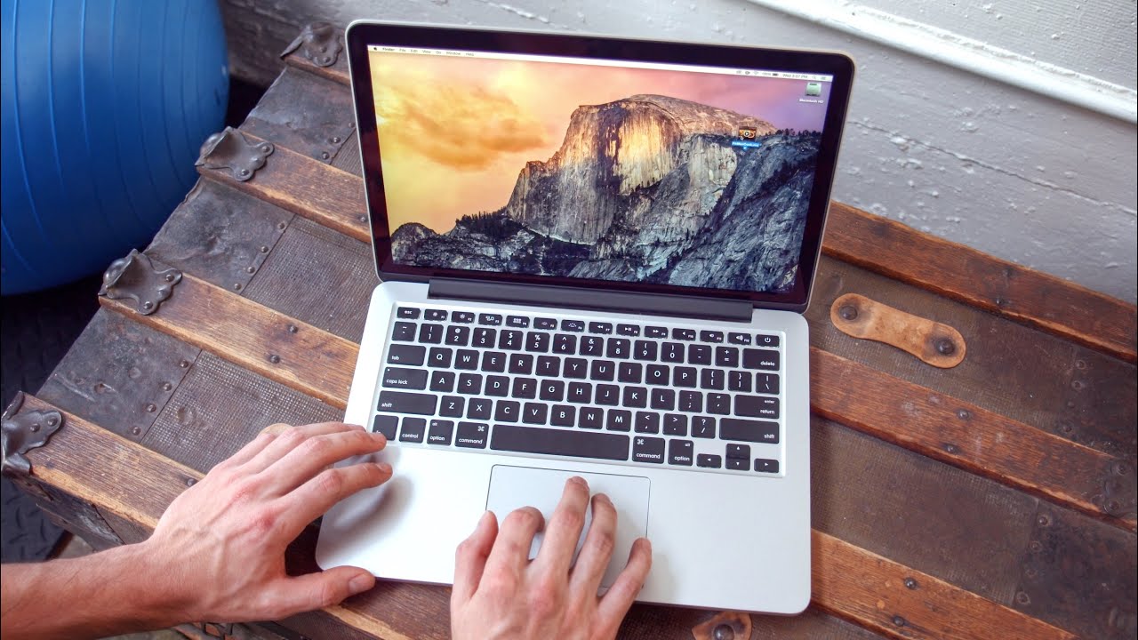 Hands on a gray MacBook laptop