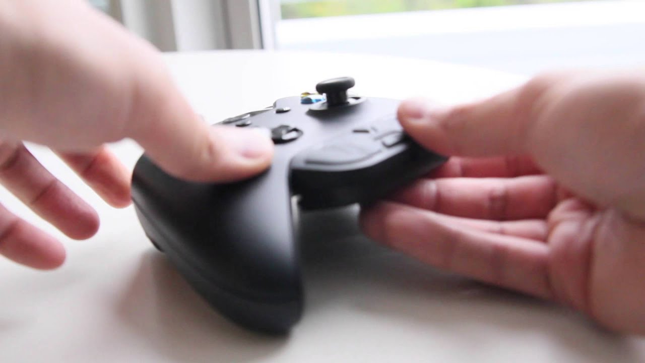 Hands holding a black controller joystick
