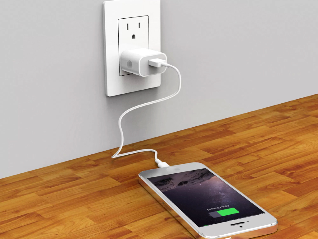 Phone charging with white cable on a socket