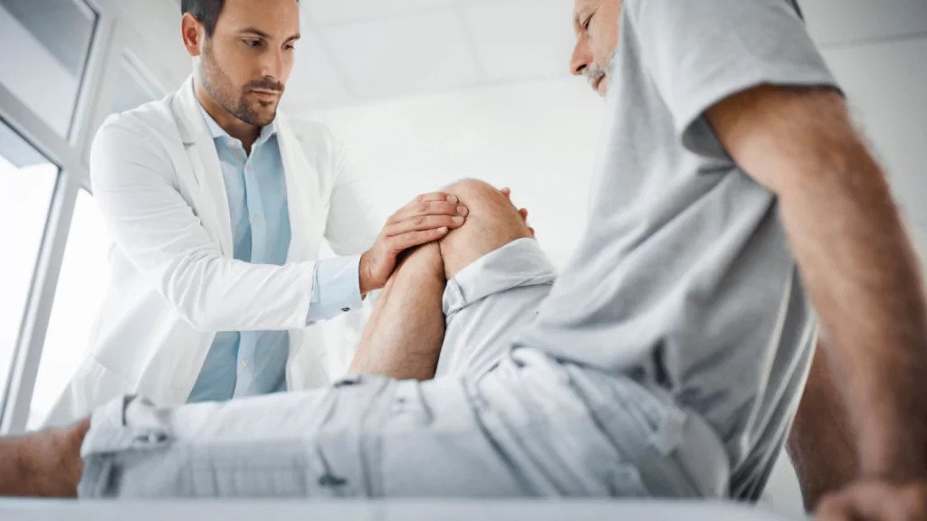 A man having his knee checked by a doctor
