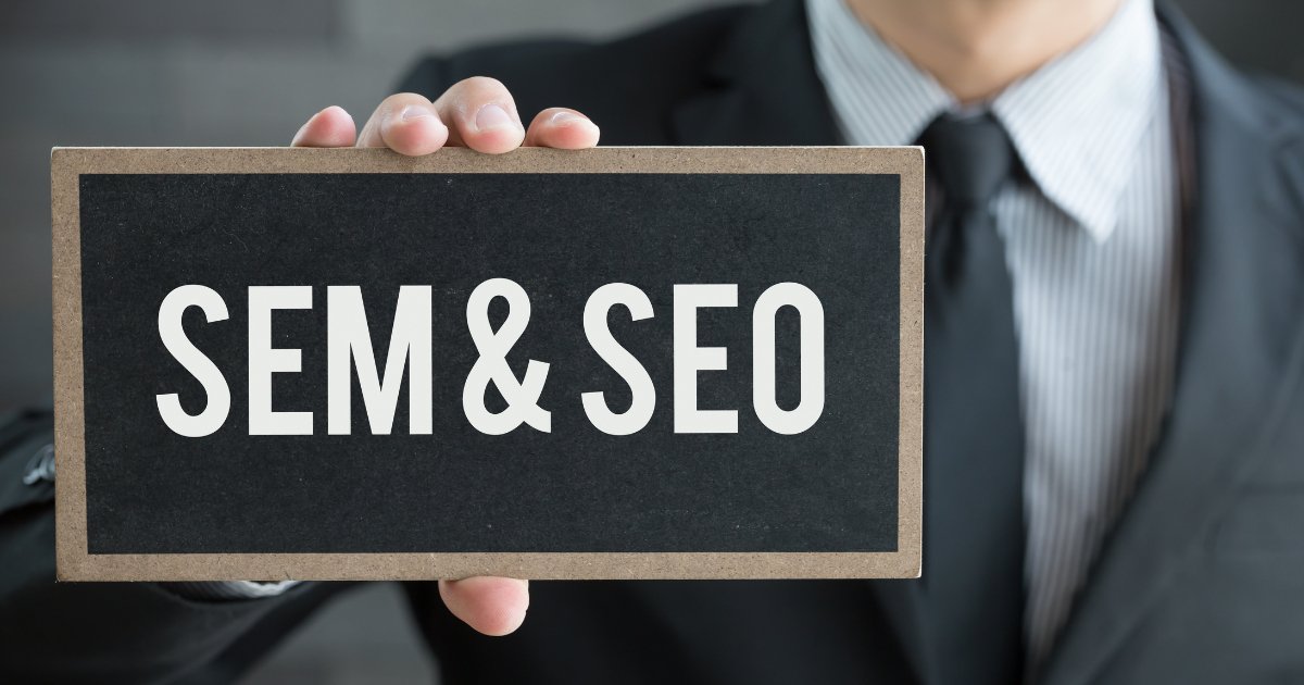 A person holding a black board with the words SEO & SEM written on it