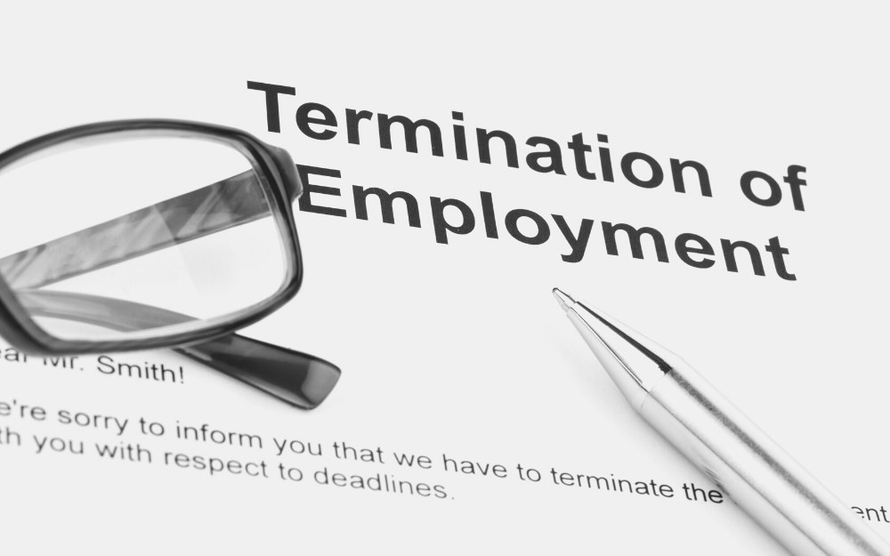 Termination employment paper, pen, and eyeglasses