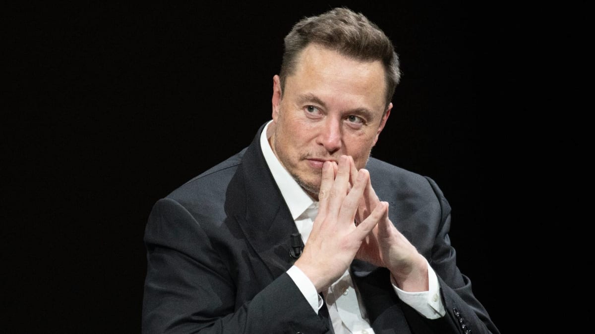 Elon Musk wearing a black suit