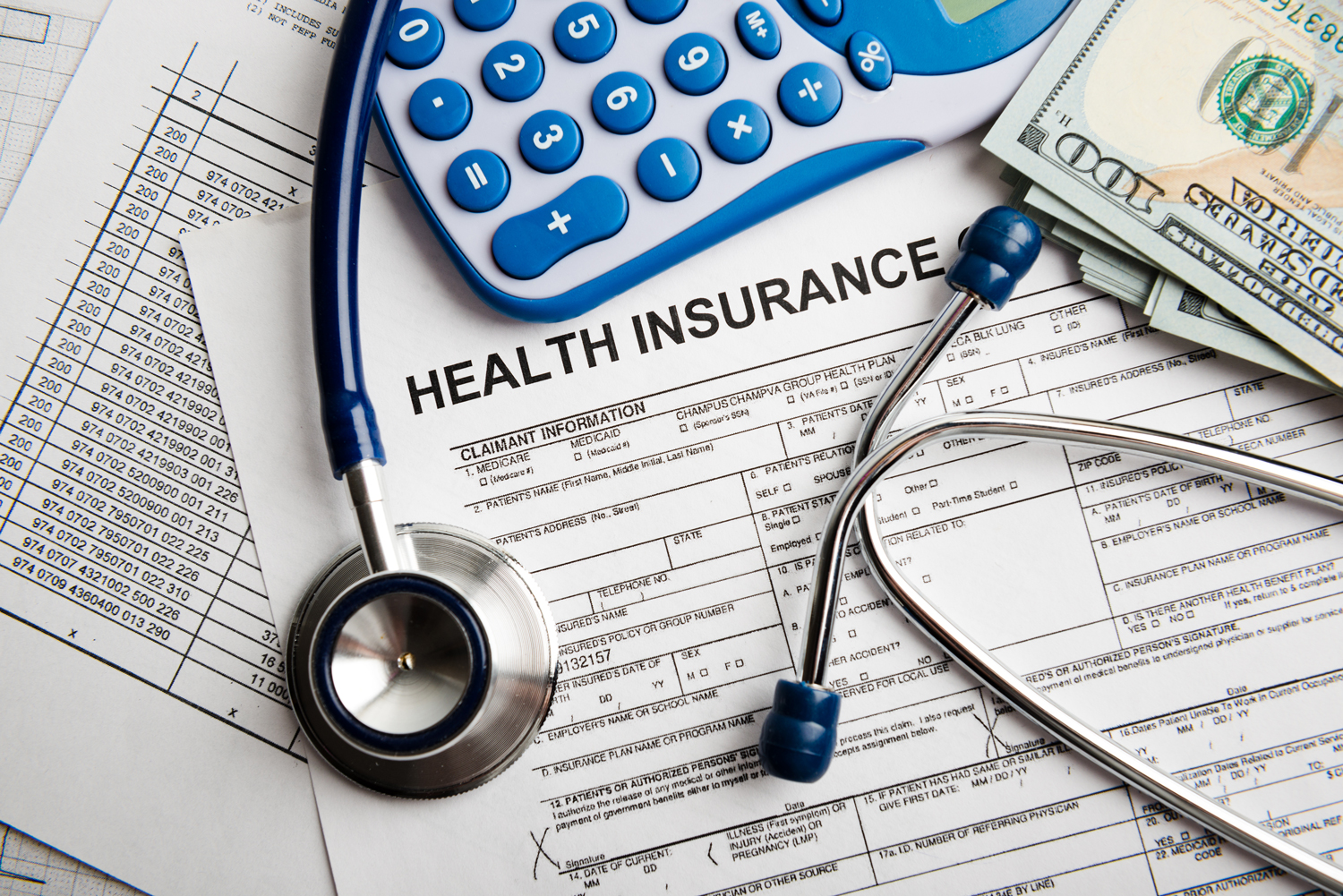 Health Insurance form, stethoscope, calculator and dollars